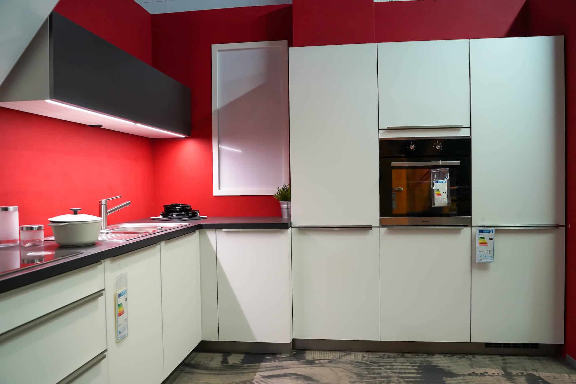 Bauformat weiße L-Küche mit Wandschrank und Elektrogeräten