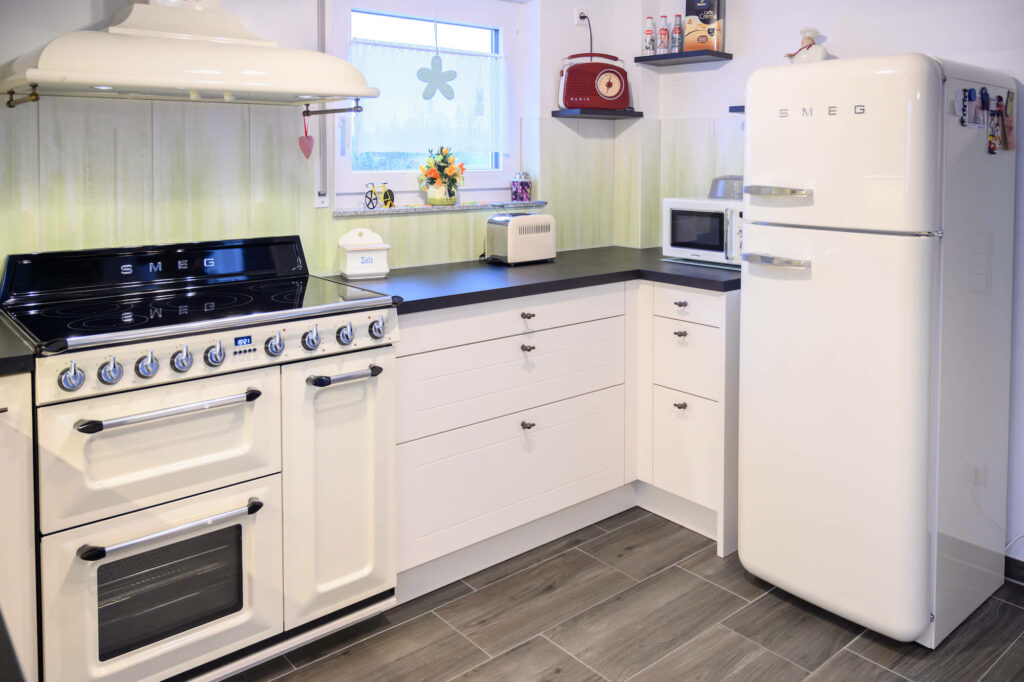 Ballerina L-Form Küche Landhausstil weiß schwarz mit SMEG E-Geräten