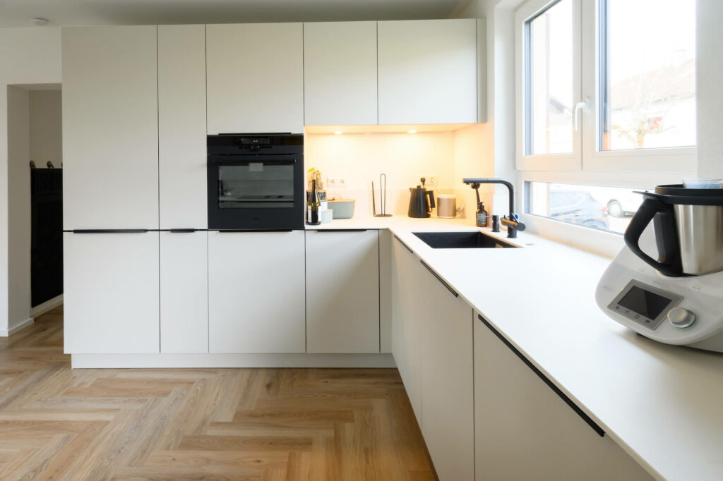 Ballerina U-Küche modern mit schwarzen griffleisten und E-Geräten
